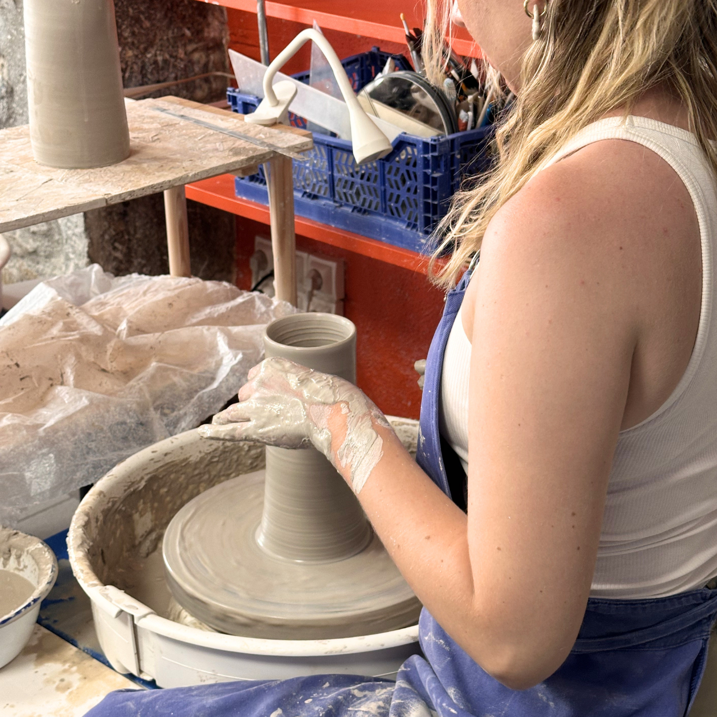 femme en train de tourner une pièce de céramqiue